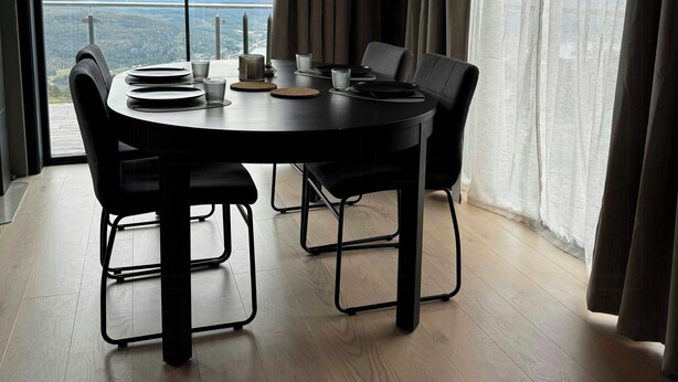 A modern dining area with a round table, chairs, and a view of the outdoors. - Modern cabin with panoramic views in Vrådal (Vrådal)