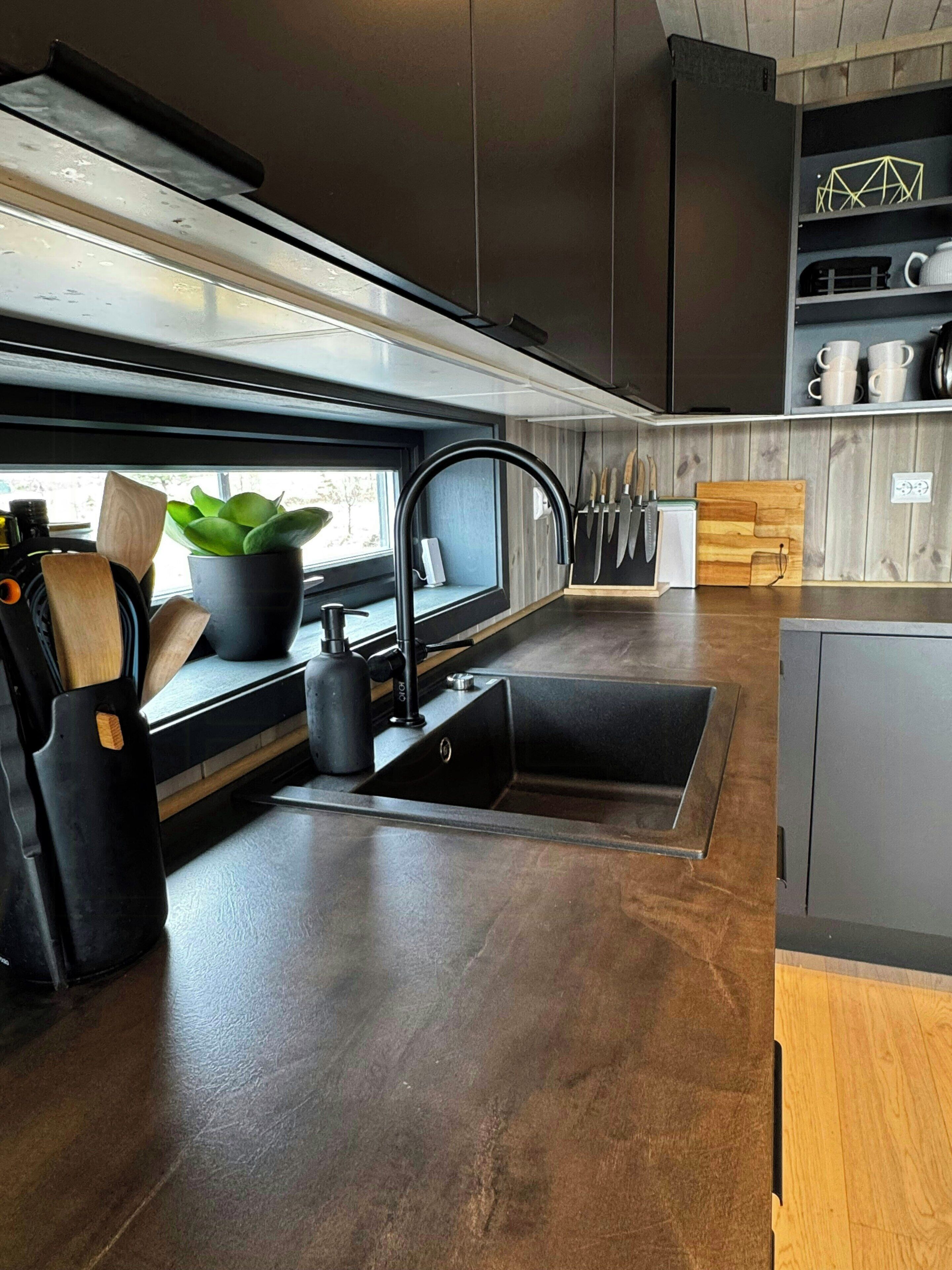 Une cuisine moderne équipée d’un évier, d’un plan de travail et d’une planche à découper en bois.