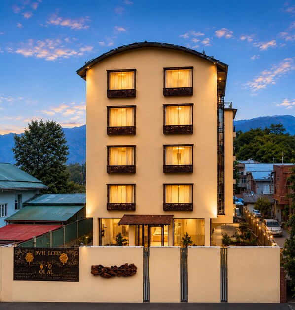 A multi-story hotel with a flat roof, multiple balconies, and a signboard at the entrance. - Royal Saffron by Stay Pattern- City Center (Srinagar)