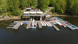 Un muelle a orillas del lago con varios barcos y un edificio con terraza.