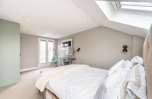 A bedroom with a skylight, a bed, a desk, and a chair. - Superb architecturally designed house in fantastic location (London)