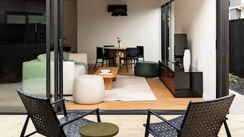 An open-plan living area with a dining table, chairs, and a sofa.