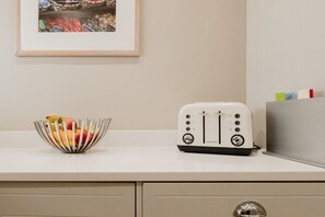 A kitchen counter with a fruit bowl and a toaster. - Stunning Garden Flat in Heart of Cheltenham (Cheltenham)