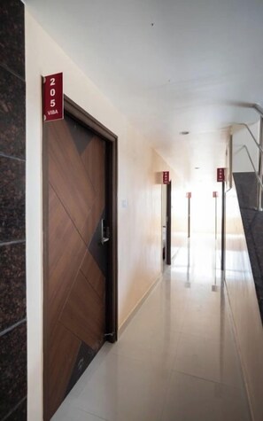 A corridor with a wooden door marked '205 VIBA' and a tiled floor. - Viba Residency (Coimbatore)
