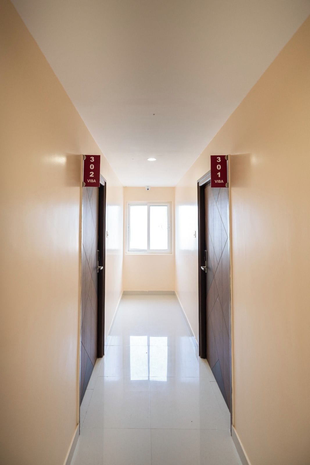 Un pasillo con dos puertas, cada una con un cartel que indica los números de habitación 302 y 301.