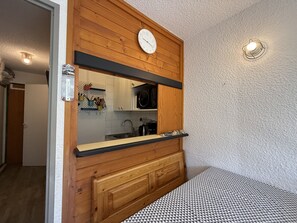 Une cuisine avec des meubles en bois, un four à micro-ondes et une horloge au mur.