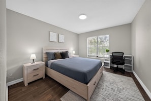 A bedroom with a bed, bedside tables, a desk, and a chair. - Comfortable Modern Home with Resort Amenities (Tamarac)