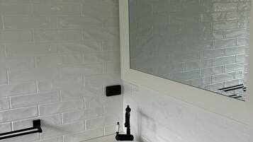 A bathroom with a white sink, a mirror, and a towel rack.