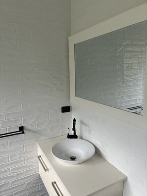 A bathroom with a white sink, a mirror, and a towel rack. - Lemongrove Cottage Berry Farm Stay (Berry)