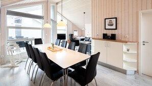 Eine moderne Küche mit Essbereich, Holzvertäfelung und einem großen Fenster.