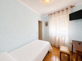 A room with a bed, a desk, and a chair.