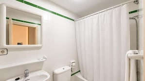 A bathroom with a sink, toilet, and shower area.
