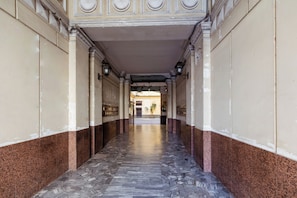A corridor with a patterned floor, columns, and a ceiling with decorative moldings. - 5 minutes from Naples' historic center and 2 minutes from Line 1, Università Station. (Napoli)