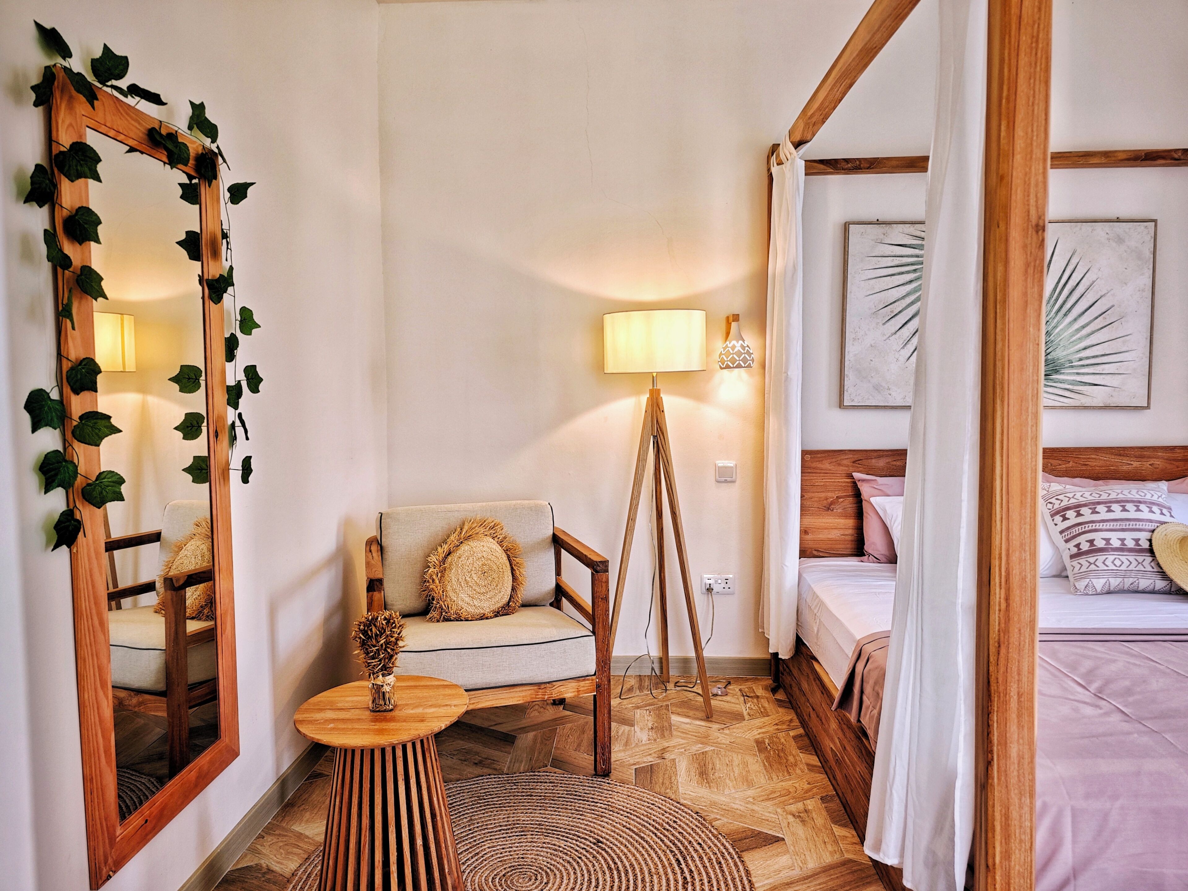 Una habitación con cama, una silla, una lámpara y un espejo.