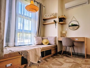 A cozy room with a bed, a desk, and a chair. There is a window with curtains, a hanging light fixture, and wall decorations. - Designer Luxury villa, 10 mins walk from beach (Grand Baie)