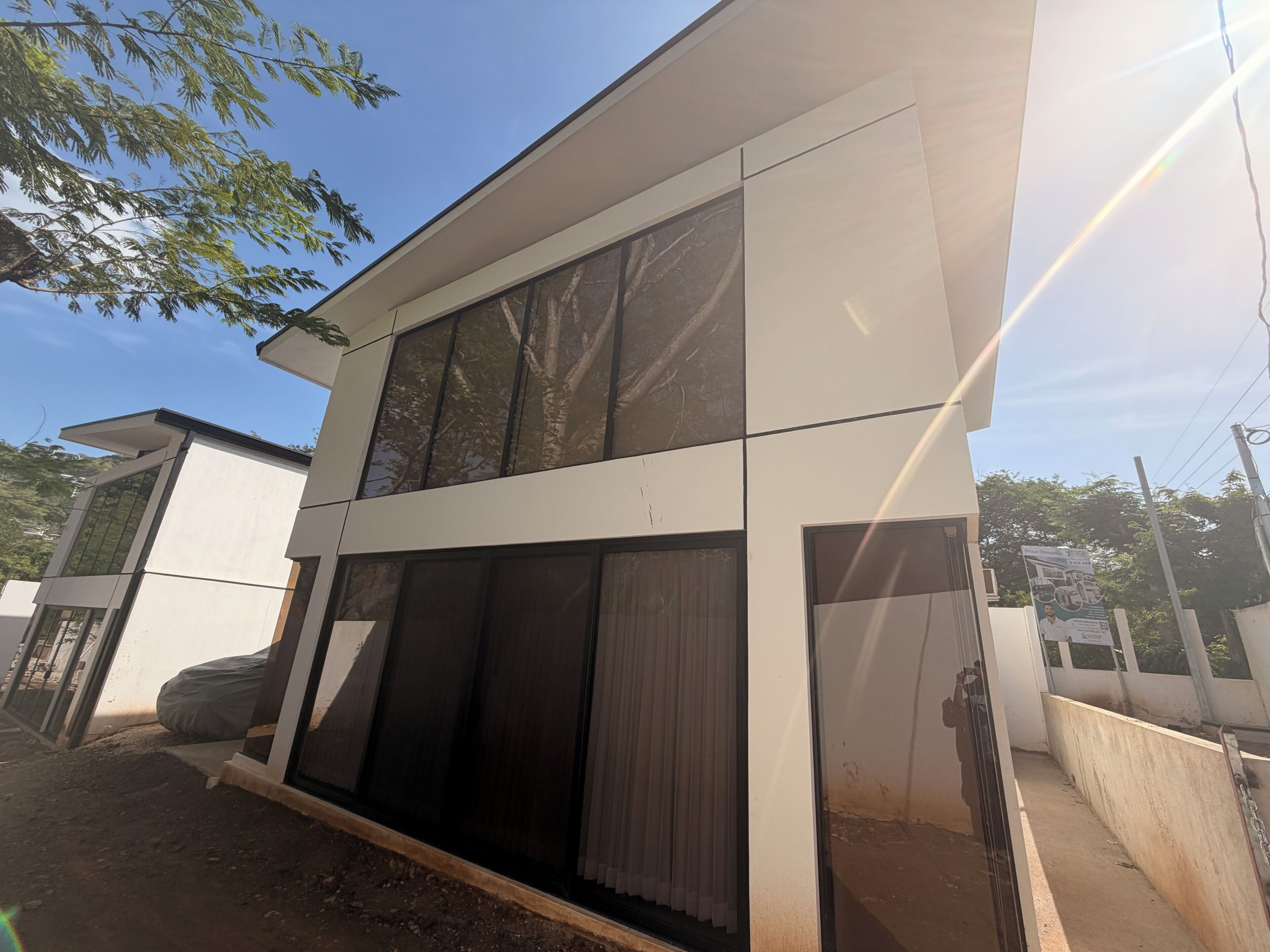 En moderne bygning med to etager, store vinduer og et fladt tag.