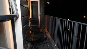 A narrow corridor with a railing on one side, leading to a door at the end. - Luxury 2-Bed Apartment | 3 Bathrooms | Balcony & Rooftop Terrace (Salford)