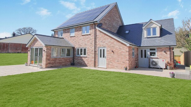 A two-story house with a brick exterior, a sloped roof, and a solar panel installation. - Cefn Coed (Presteigne)