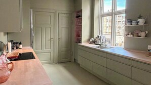 Een keuken met raam, kastjes en een aanrecht.