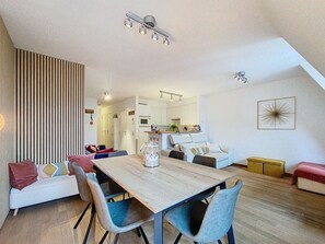 A modern interior with a dining area, kitchen, and living space. - "Emmy" Apartment – Oostduinkerke – Cozy vacation apartment near the beach (Koksijde)