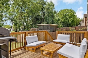 Eine Terrasse im Freien mit Holzmöbeln und einem Grill.