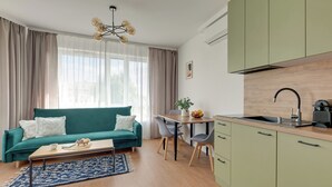 A compact living space with a sofa, a dining table, and a kitchenette. - Śląska 416 | Gym | AC & Parking (Gdańsk)