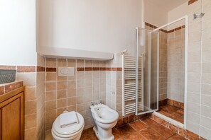 Ein Badezimmer mit Toilette, Bidet und Duschbereich.
