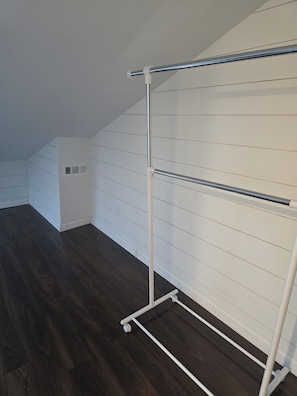 Una habitación con techo blanco, tejado inclinado y suelo de madera.