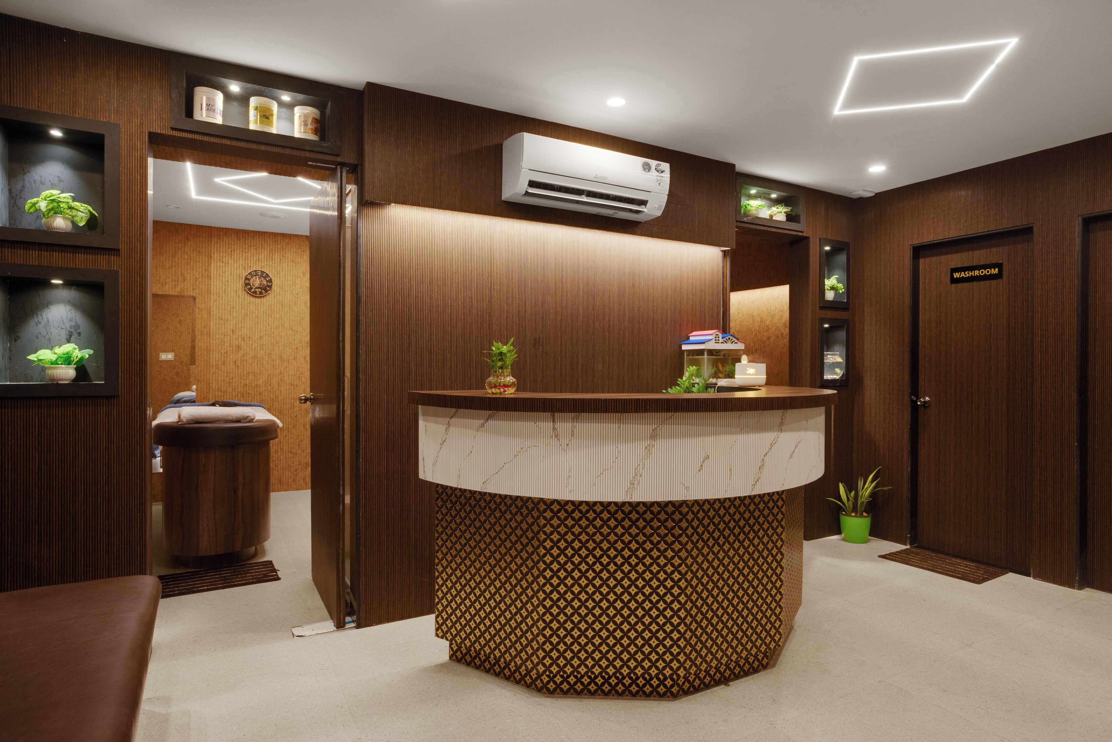 A reception area with a wooden reception desk, a clock, and a wall-mounted air conditioner.