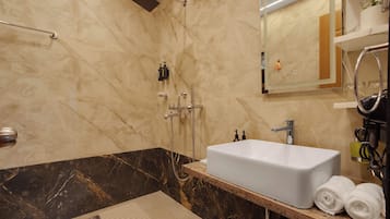 Ein modernes Badezimmer mit einem großen weißen Waschbecken, einer Handbrause und einem Spiegel über dem Waschbecken.