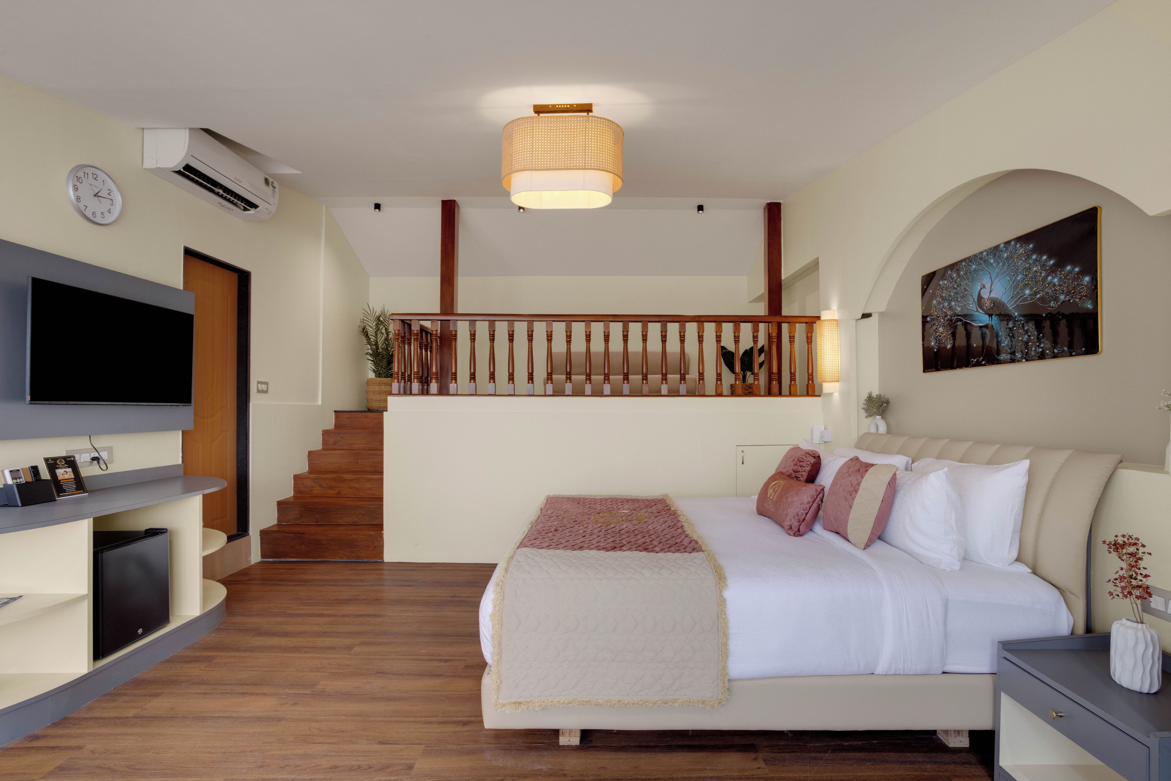 Una camera da letto con un letto, una televisione, una scala e un orologio a muro.