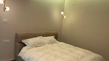 Un dormitorio con cama, aire acondicionado y luces colgantes.