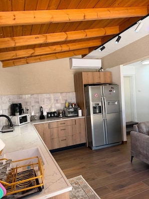 A compact kitchen with a built-in microwave, toaster, and refrigerator.