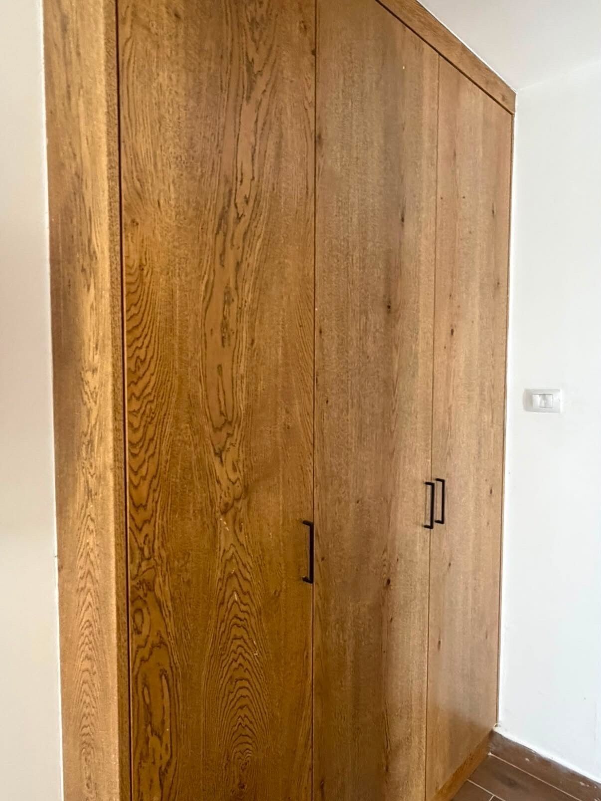 A large wooden wardrobe with two handles.