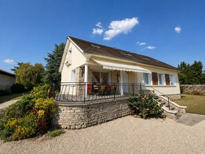 A two-story house with a stone foundation, a covered porch with outdoor seating, and a stone wall. - Le Clos Nicole - Family home for 12 people with a large garden (Autheuil-en-Valois)