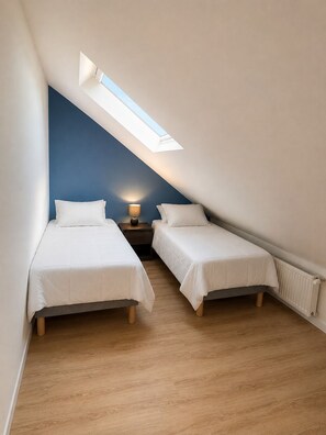 A bedroom with two beds, a skylight, and a nightstand with a lamp. - Le Clos Nicole - Family home for 12 people with a large garden (Autheuil-en-Valois)