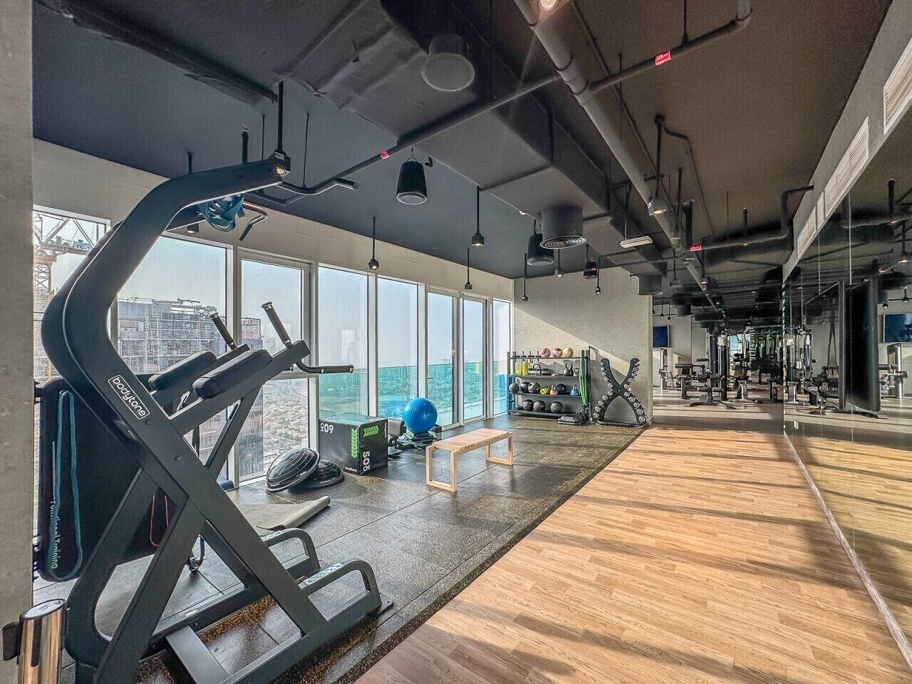 Une salle de sport équipée de machines de cardio, de poids et d’un banc.