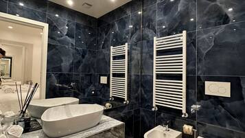 Ein modernes Badezimmer mit einem großzügigen freistehenden Waschbecken, einem Bidet und einer Toilette.
