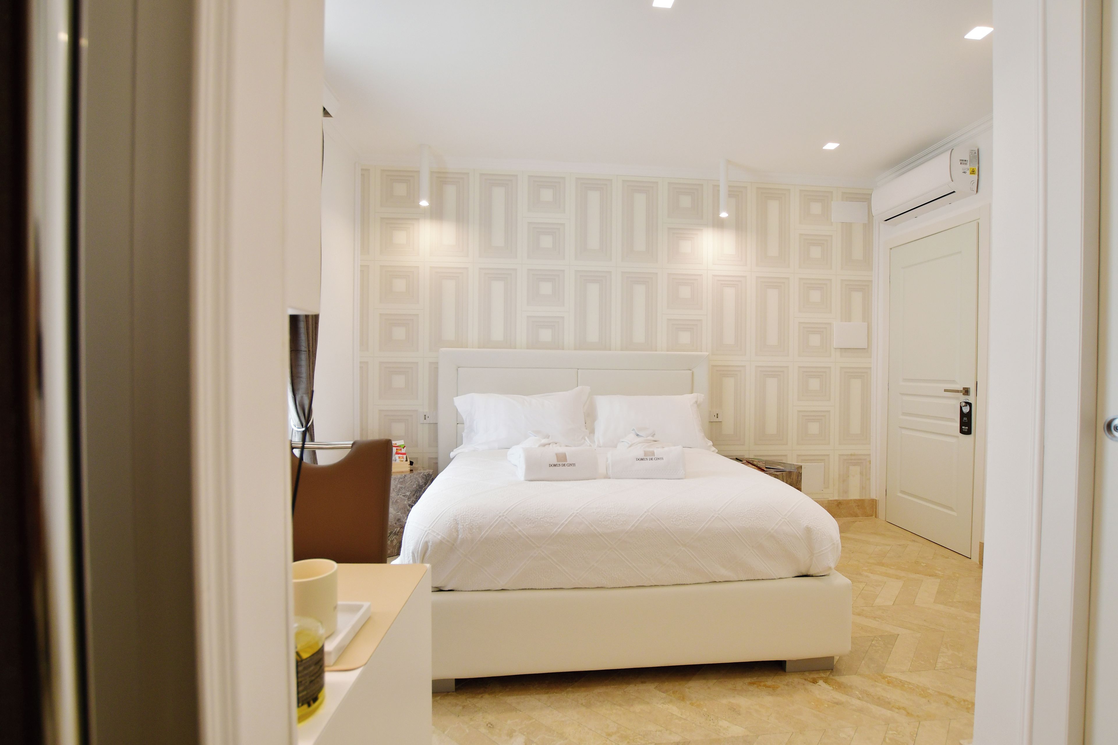 Ein Hotelzimmer mit einem großen Bett, einem Nachttisch, einem Sessel und einem Kleiderschrank.