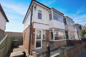 A two-story residential building with a white facade, large windows, and a visible satellite dish. - Spacious 4BR near Hornsea Museum | Sleeps 8+WiFi (Hornsea)