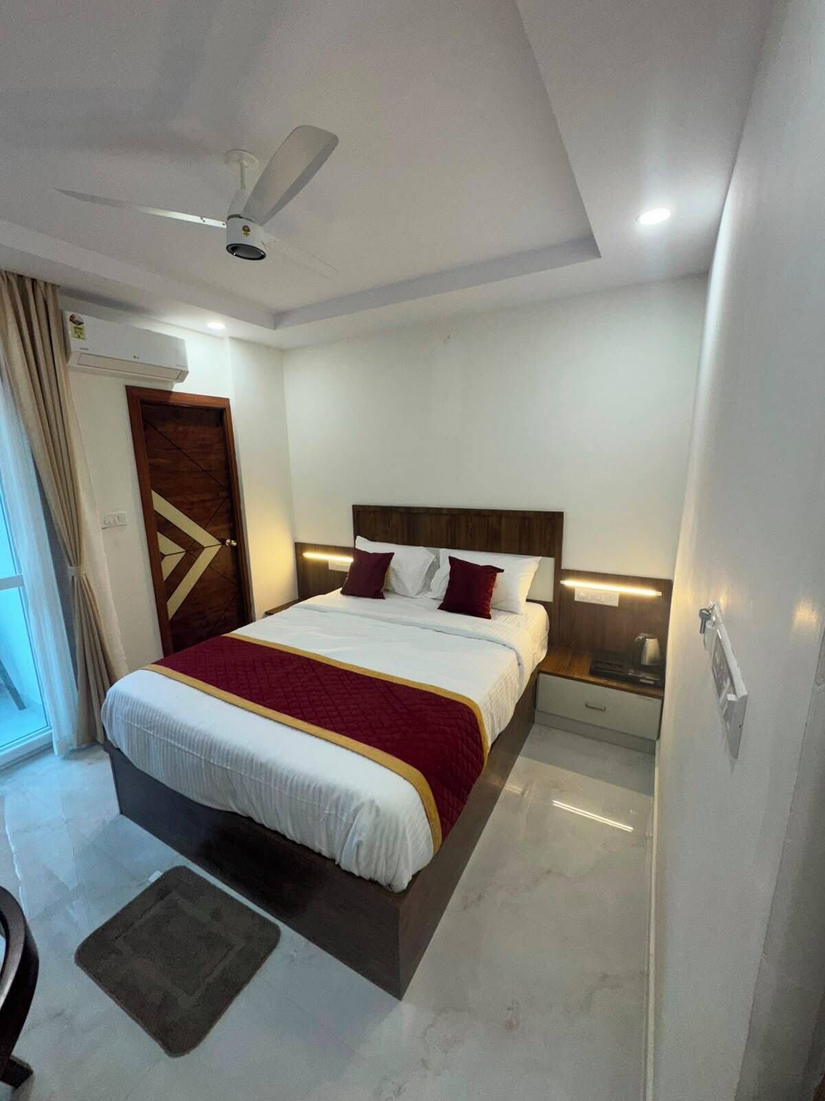 A modern bedroom with a bed, bedside tables, a ceiling fan, and an air conditioning unit.