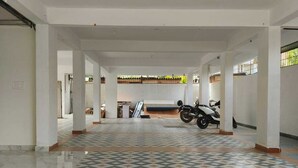 Un interno spazioso con un pavimento piastrellato decorato, una motocicletta parcheggiata al centro e un corridoio che porta a una porta.