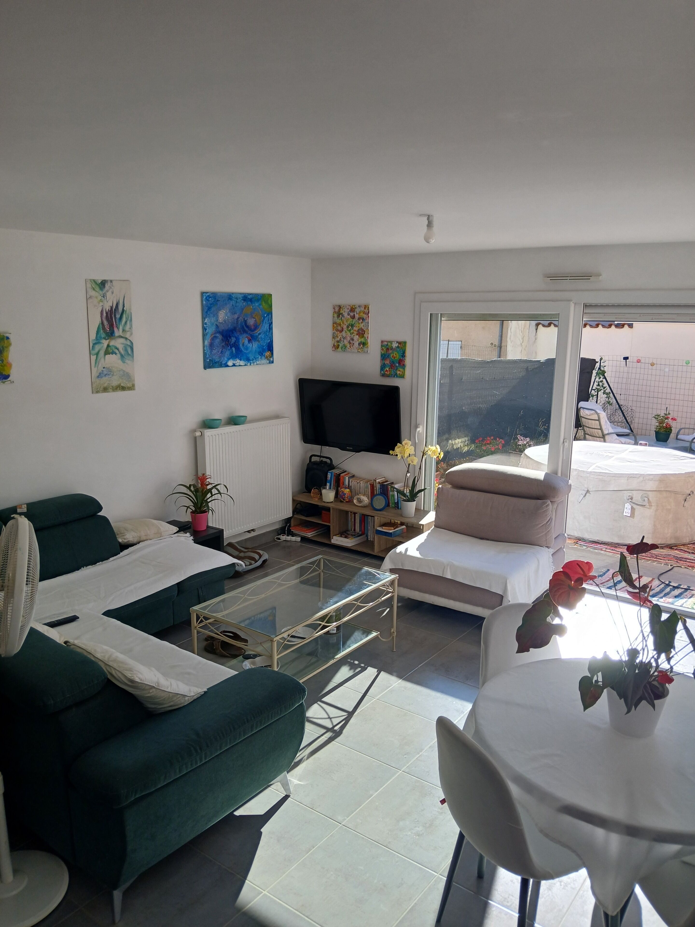 A living room with a sofa, a coffee table, a TV, and a dining area with a table and chairs.