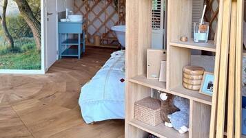 A cozy room with a wooden bookshelf, a small table, and a bed with a white bedspread.