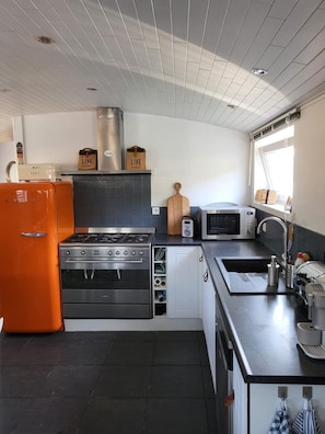 A modern kitchen with a gas stove, oven, microwave, and a sink.