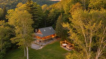 A quiet cabin in the woods with hills all around. Sit out on the porch and enjoy the fresh air, then take a short walk across the lawn to the hot tub and sauna for a relaxing night under the lights.