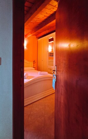 Un dormitorio con cama, armario y puerta que da a otra habitación.