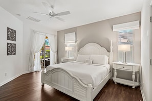 A bedroom with a white bed, a nightstand, a ceiling fan, and a window with blinds. - 4036 Oakrise Loop (Davenport)