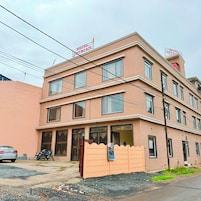 Un hotel de varios pisos con fachada plana, amplias ventanas y una entrada porticada.