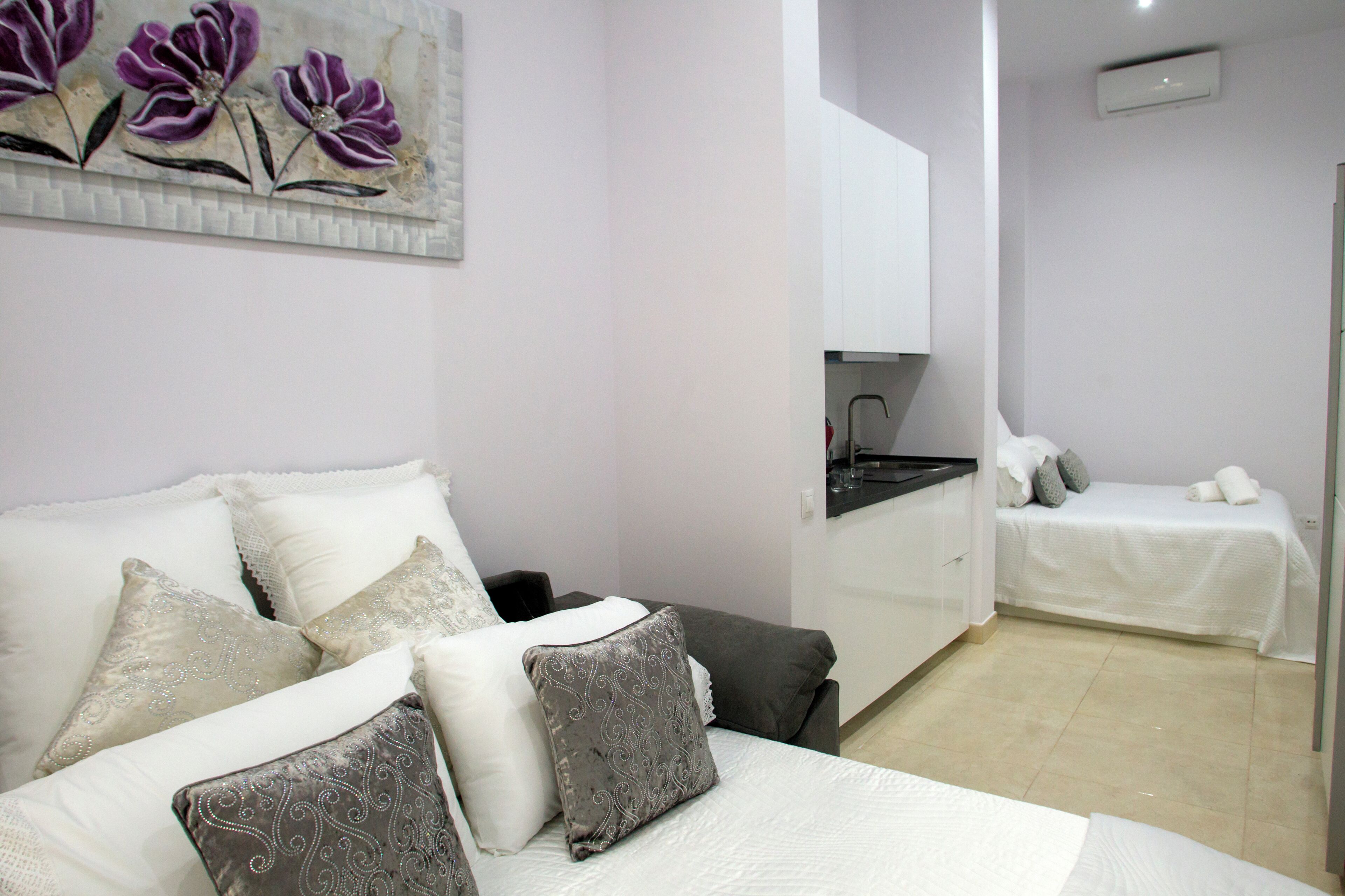 A hotel room with a bed, a small kitchenette, and a separate sleeping area.